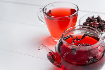 Red tea,brewed in a transparent teapot.Dry tea leaves, white background.The view from the top.