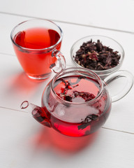 Red tea,brewed in a transparent teapot.Dry tea leaves, white background.The view from the top.