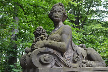 Posąg kobiety, rzeżba parkowa wsród zielonych drzew