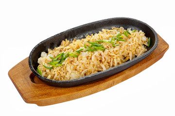 chahan with chicken, pork, with meat, green onions serving on a hot frying pan, on a wooden board on white isolated background side view. For the menu, restaurant, bar, cafe