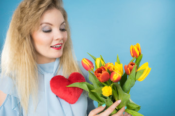 Obraz na płótnie Canvas Woman holds tulips and red heart