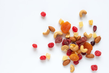 healthy snack: mixed nuts and dried fruits on white background from above, almond, pineapple, cranberry, papaya, apple, strawberry, cherry, apricot, casshew.