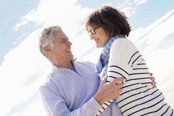 Obraz premium Portrait of senior couple embracing by the beach