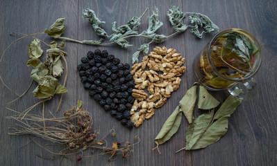 heart of dried cherries, nuts and dried leaves of tea, cup of herbal tea on the windowsill