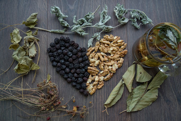 heart of dried cherries, nuts and dried leaves of tea, cup of herbal tea on the windowsill