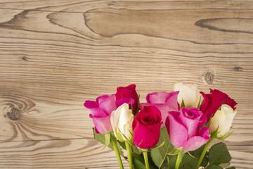 Einen Strauß Rosen vor einem Holz Hintergrund