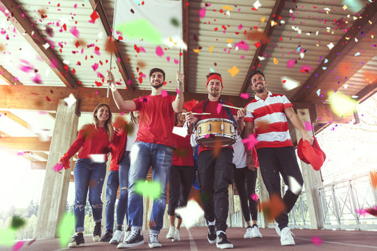 group of fans dressed in red color walking under the roof
