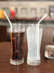 Soft drink and water in glass with ice