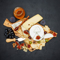 Brie cheese on a wooden Board with fresh figs and grapes