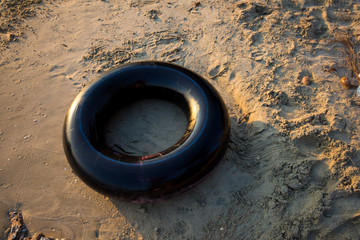 Black rubber ring (buoy) on the beach