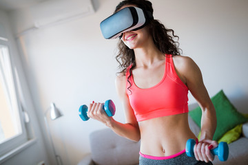 Young woman doing exercises wearing vr goggles