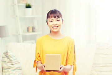 people, delivery, commerce, shipping and shopping concept - happy asian young woman with cardboard parcel box at home