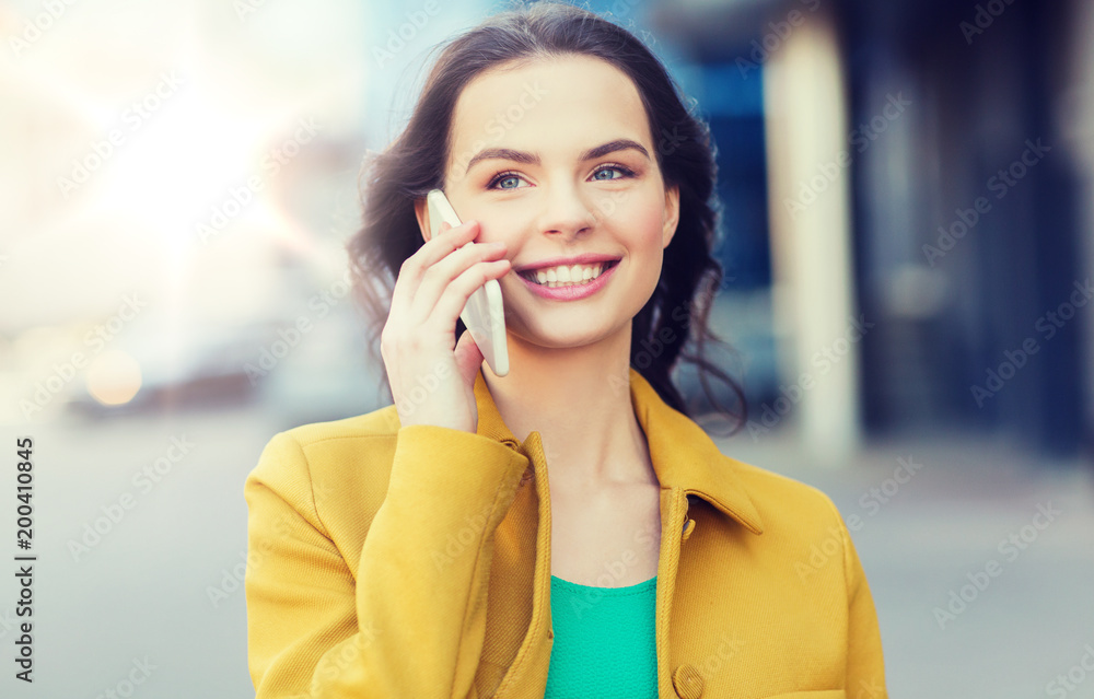 Poster technology, communication and people concept - smiling young woman or girl calling on smartphone on city street