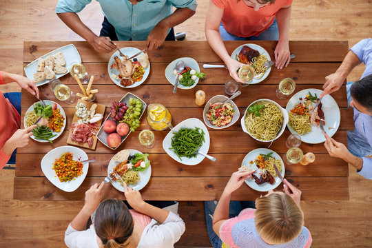 Eating And Leisure Concept - Group Of People Having Dinner At Table With Food