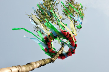 Ein geschmückter Maibaum vor strahlend blauen Himmel