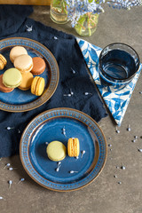 Macaroons and coffee. Dark blue plate, gray background. 