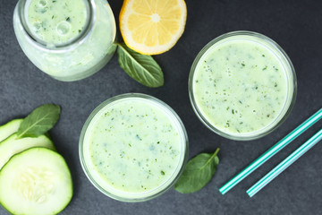 Refreshing green cucumber, yogurt, mint and lemon smoothie in glasses, photographed overhead on...