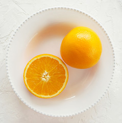 orange fresh on the whote plate, top view