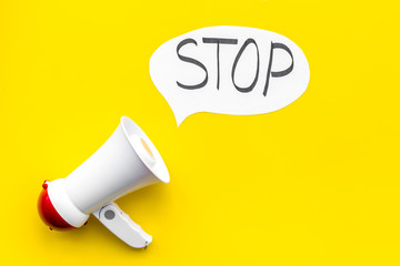 Demand to stop concept. Megaphone near cloud with word stop on yellow background top view space for text