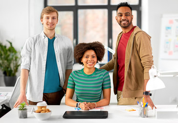 business and people concept - happy creative team with laptop at office