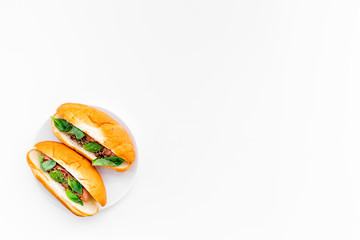 Homemade hot dogs with grilled sausages and greenery on white background top view copy space