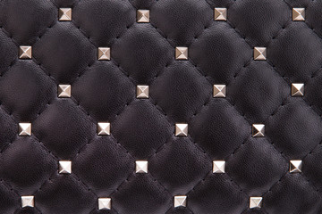 Fragment of black leather with metal spikes