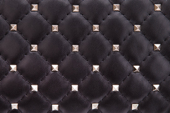Fragment of black leather with metal spikes