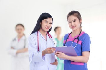 Fototapeta premium Beautiful Asian doctor and nurse, meadical team smiling at camera