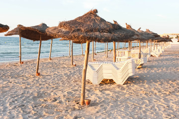 sun beds and straw umbrellas on the beach