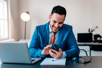 Handsome businessman checking email on his phone.