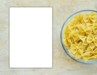 farfalle macaroni Pasta in a glass cup on a wooden table textured background with a side. Close-up with the top. White space for text and ideas.
