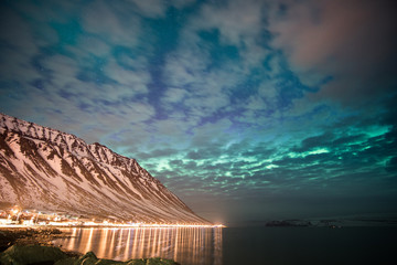 northern lights over the mountains and a cloudy sky