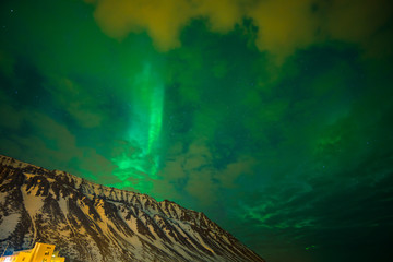 northern lights over the mountains and a cloudy sky