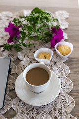 A cup of coffee with milk and cookies