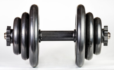 Black heavy dumbbell with rubberized discs and a rubberized handle for exercising in the gym