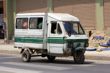 White electric car, minibus with passengers (public transport, fixed route taxi) in Kathmandu, Nepal