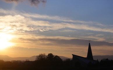 Obraz premium Landscape and church, cross silhouette on cloudy sunset sky
