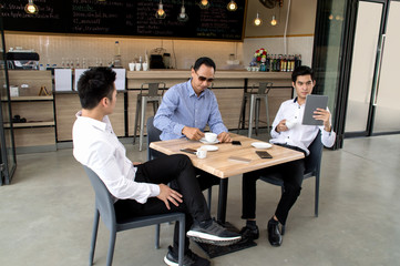 Three young business friends Meeting In Coffee Shop