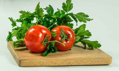 Ripe juicy tomatoes and parsley in the kitchen