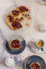Blackberries buns. White background and blue plates. Coffee and flowers.