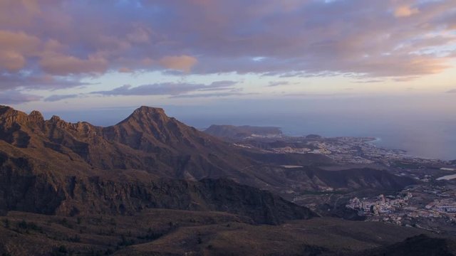Time lapse of volcanic mountains in Las Americas coastline at sunset, in Tenerife, Canary islands, Spain.