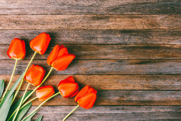 bouquet of red tulips on wooden retro grunge background with copy space. The concept of Mothers Day, womens day, top View