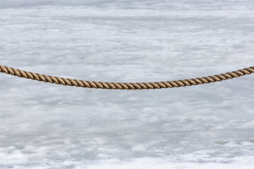 Fence rope on a snow-melting background.