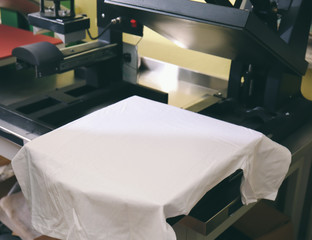 Modern printing machine with t-shirt at workplace