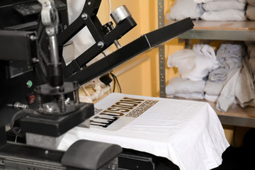 Modern printing machine with t-shirt at workplace