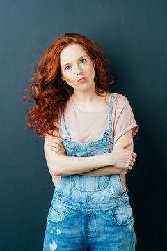 Intense young woman in trendy dungarees