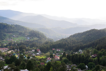 Fototapeta na wymiar Landscape village surrounded by forest and mountains