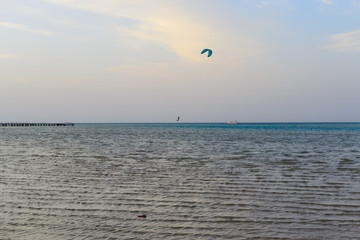 Kitesurfing silhouette on the horizon of the sea