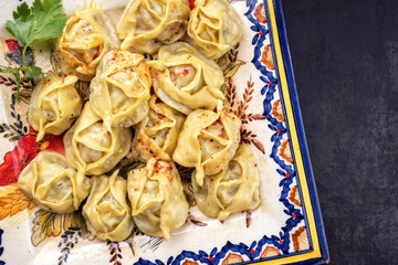 Traditional Kazakh manti steamed with mincemeat as top view on a plate