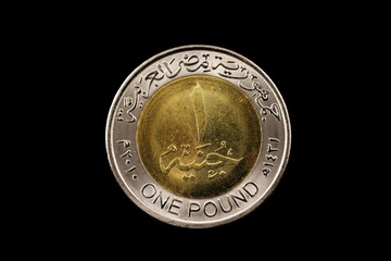 A macro image of a one pound coin from Egypt isolated on a black background